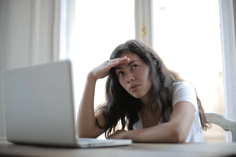 Woman waiting for a response at her laptop, visibly frustrated