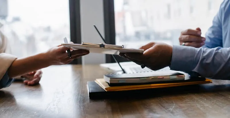 Clipboard with documents being reviewed at a desk during a business meeting