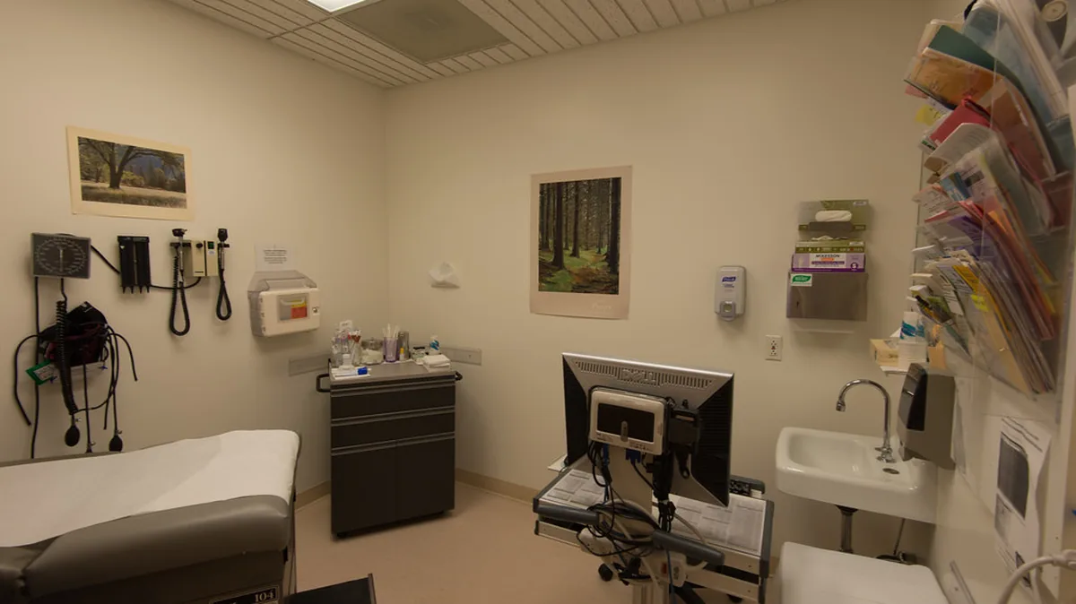 Medical exam room with examination table, blood pressure cuff, and computer — where CDL drivers go for DOT physicals