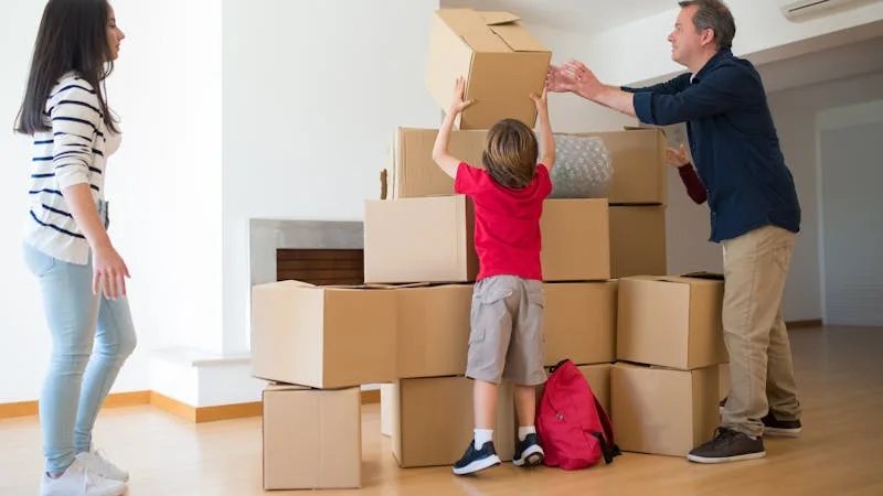 Family with stacked moving boxes inside an empty new home