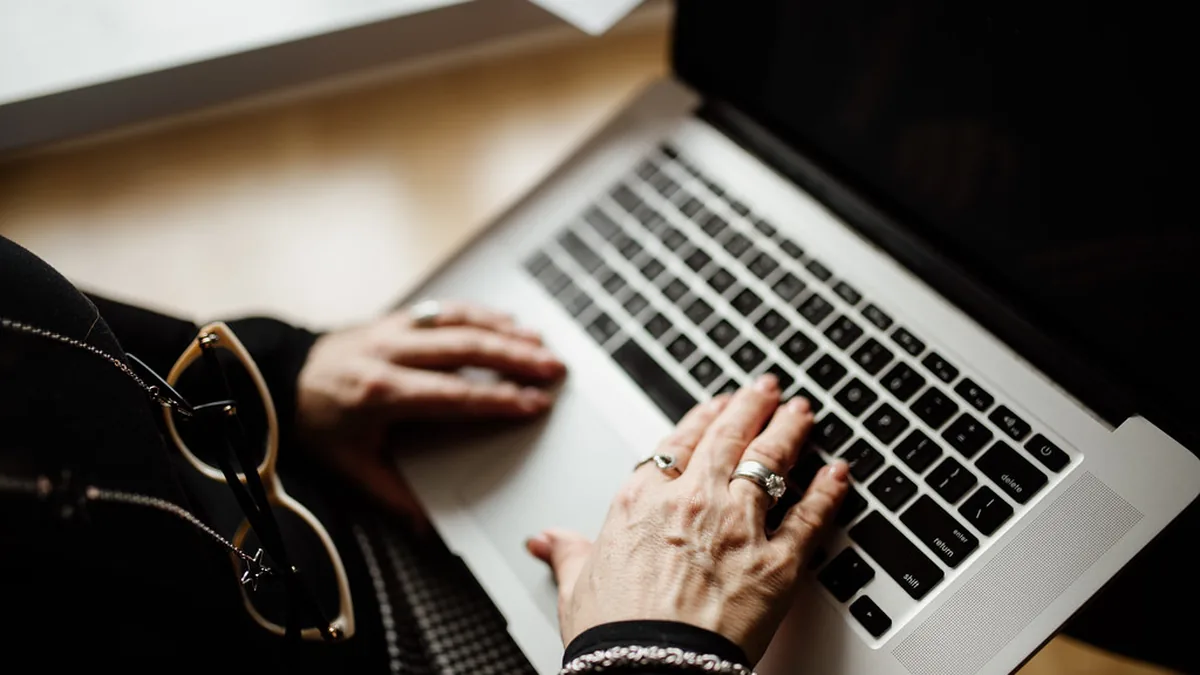 Business owner typing on a laptop — responding to customer reviews is one of the highest-ROI activities for local SEO