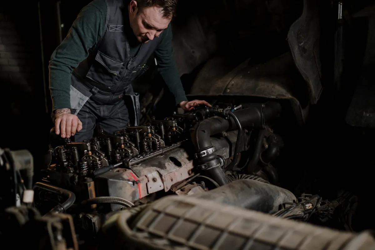 Mechanic repairing a truck engine in a workshop